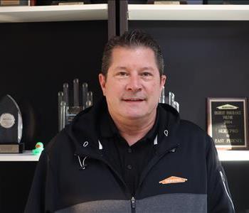 Professional headshot of Jason Wolfswinkel, owner of SERVPRO of Phoenix, in a branded SERVPRO polo, smiling against a clean b